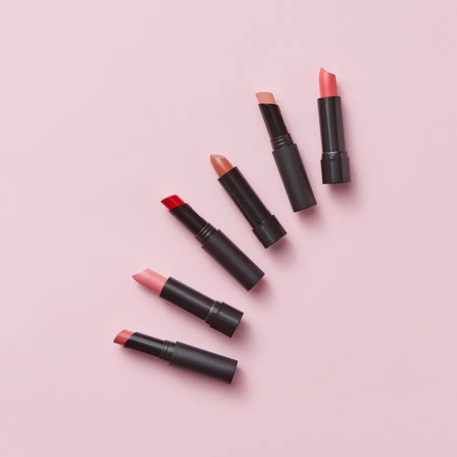 Läppstift i rosa och röda nyanser på rosa bakgrund